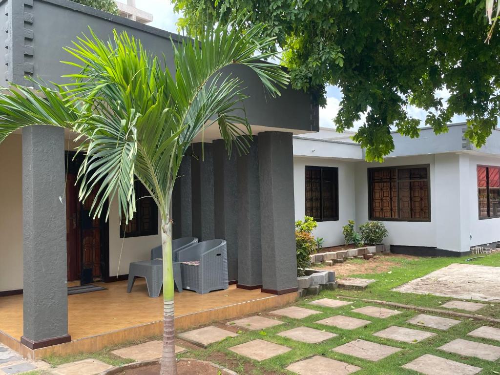 a palm tree in front of a house at Masaki Comfort III Dar es Salaam Tanzania in Dar es Salaam