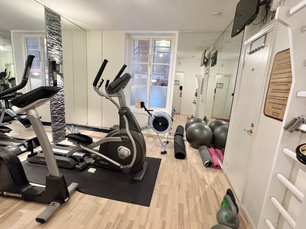 Niewielka siłownia z orbitrekiem, ergometrem wioślarskim, piłkami fitness i lustrami