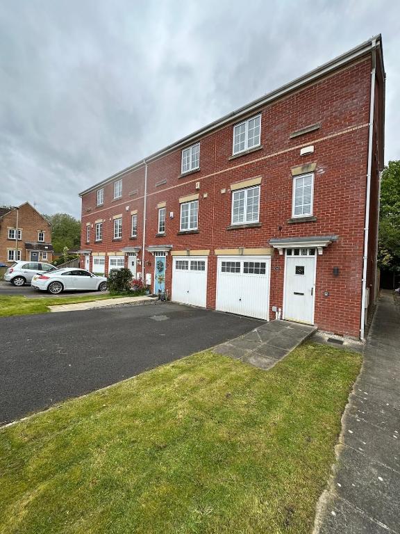 a large red brick building with white garage doors at Mmc serviced accommodation 2 in Leigh