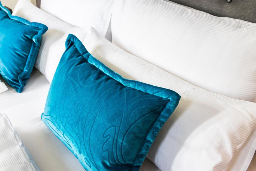a white bed with blue pillows on it at Motel One Koblenz in Koblenz