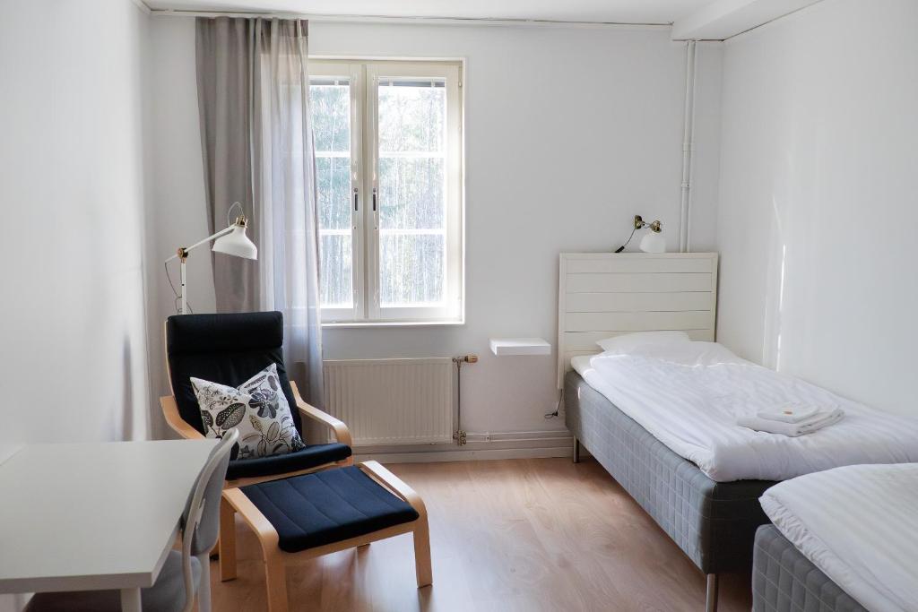a bedroom with a bed and a desk and a chair at Strömbäcks Vandrarhem in Umeå