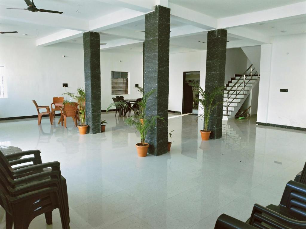 a lobby with plants in pots and chairs at Pie Restuarant and HomeStay in Baihar