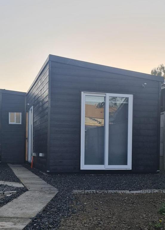 a black house with a window on the side of it at Cabañas Bio Bio Osorno in Osorno