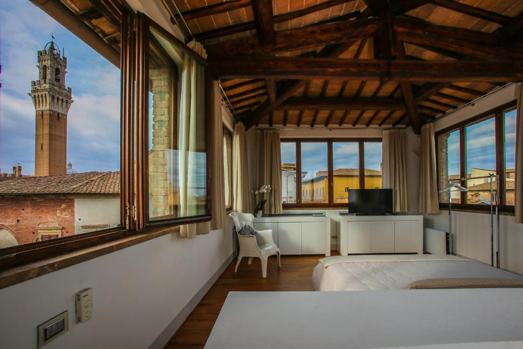 1 Schlafzimmer mit 2 Betten und einem großen Fenster in der Unterkunft B&B Le Logge Luxury Rooms in Siena
