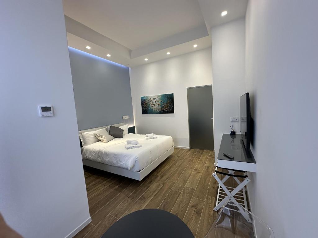a bedroom with a bed and a flat screen tv at Alloggio degli Eroi by LocazioniOK in Mola di Bari