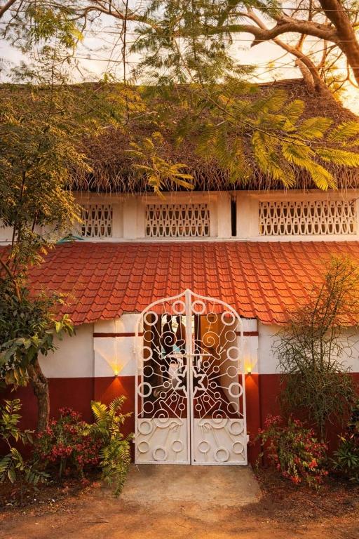 a gate to a house with an orange roof at Luxury 3BHK Pool Villa Near Beach Pondicherry in Pondicherry