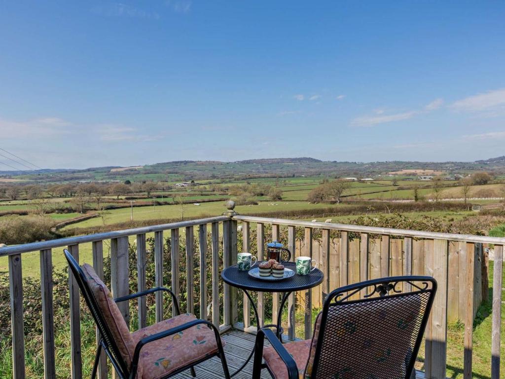 a table and two chairs on a balcony with a table at 1 Bed in Bridport oc-90055 in Whitchurch Canonicorum