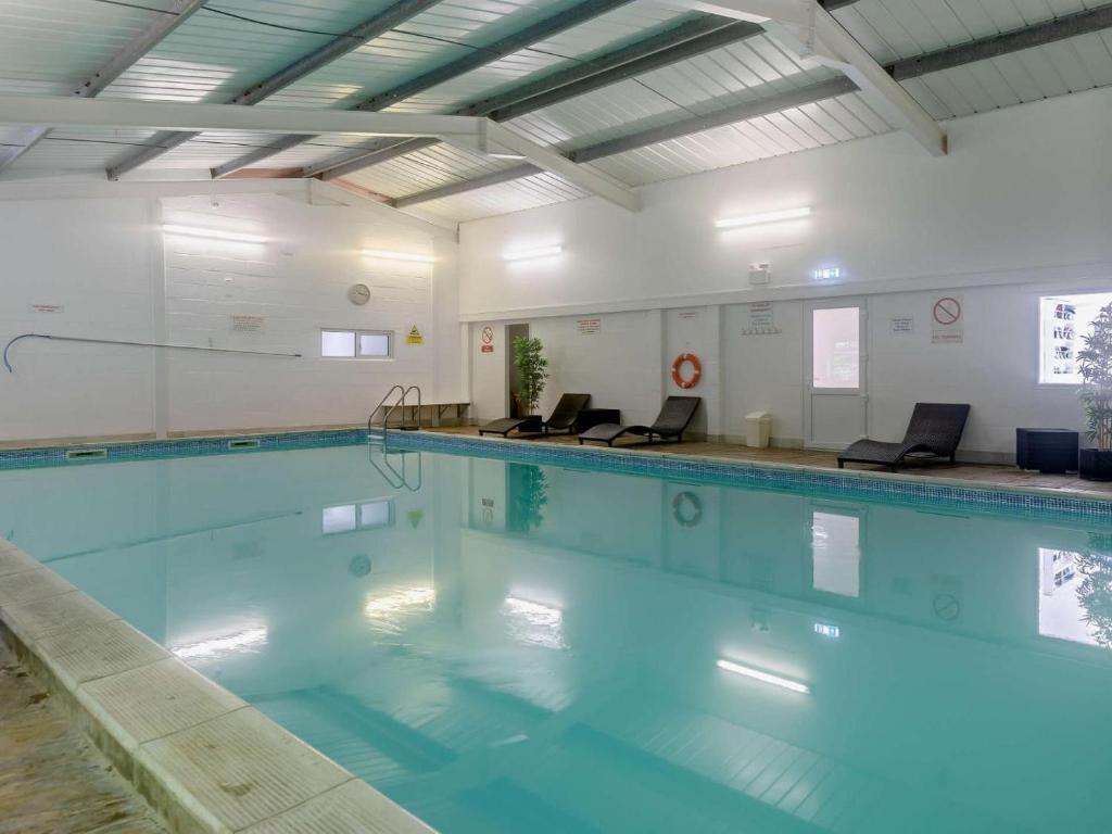 a large swimming pool with blue water at 3 Bed in Bude oc-trvvv in Poughill