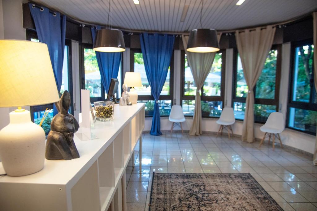 a room with blue curtains and a table with a lamp at LUDO Holiday House in Riccione