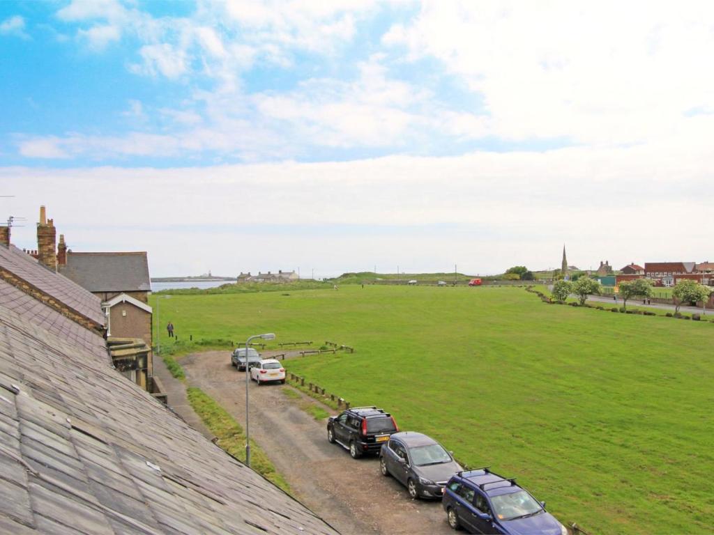 a row of cars parked on a road next to a field at 3 Bed in Morpeth oc-cn137 in Amble