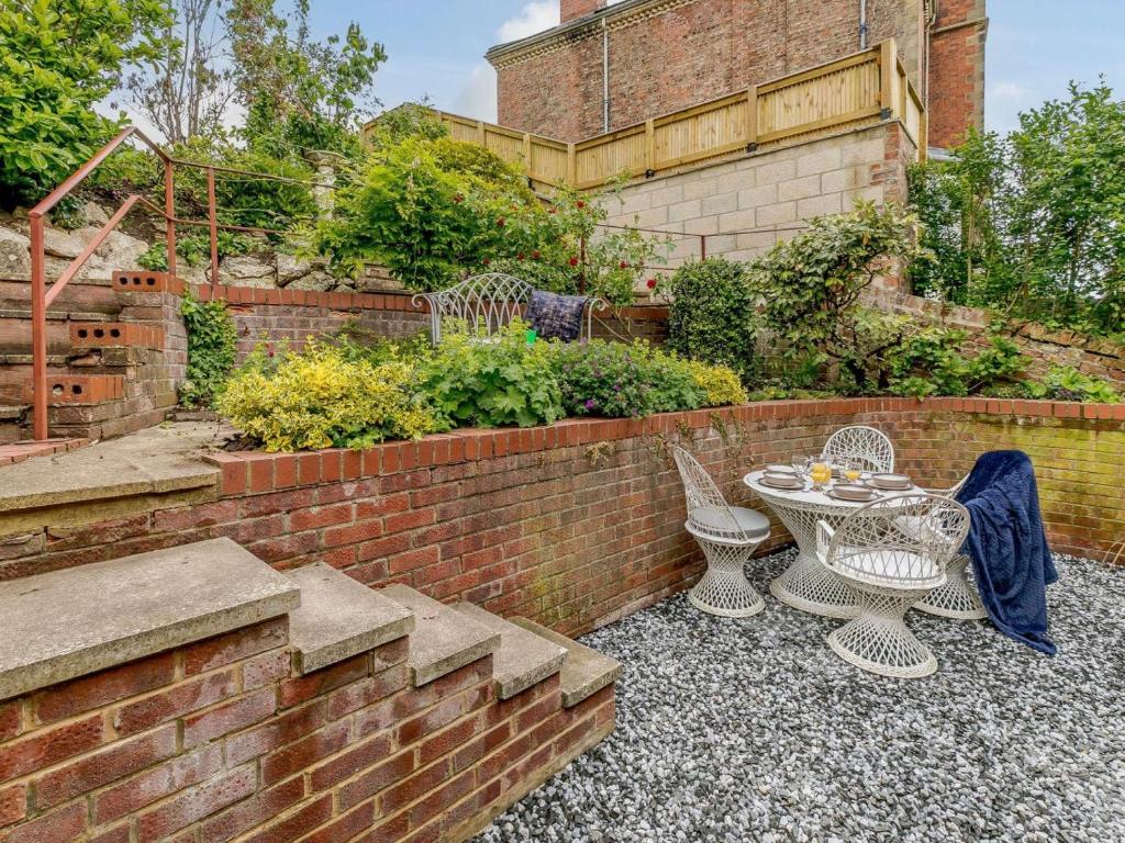 a patio with a table and chairs and a brick wall at 2 Bed in Ripon oc-88051 in Ripon