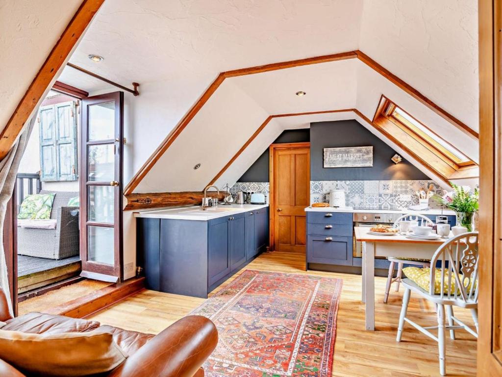 an attic kitchen with blue cabinets and a table at 1 Bed in Wedmore oc-51340 in Chapel Allerton