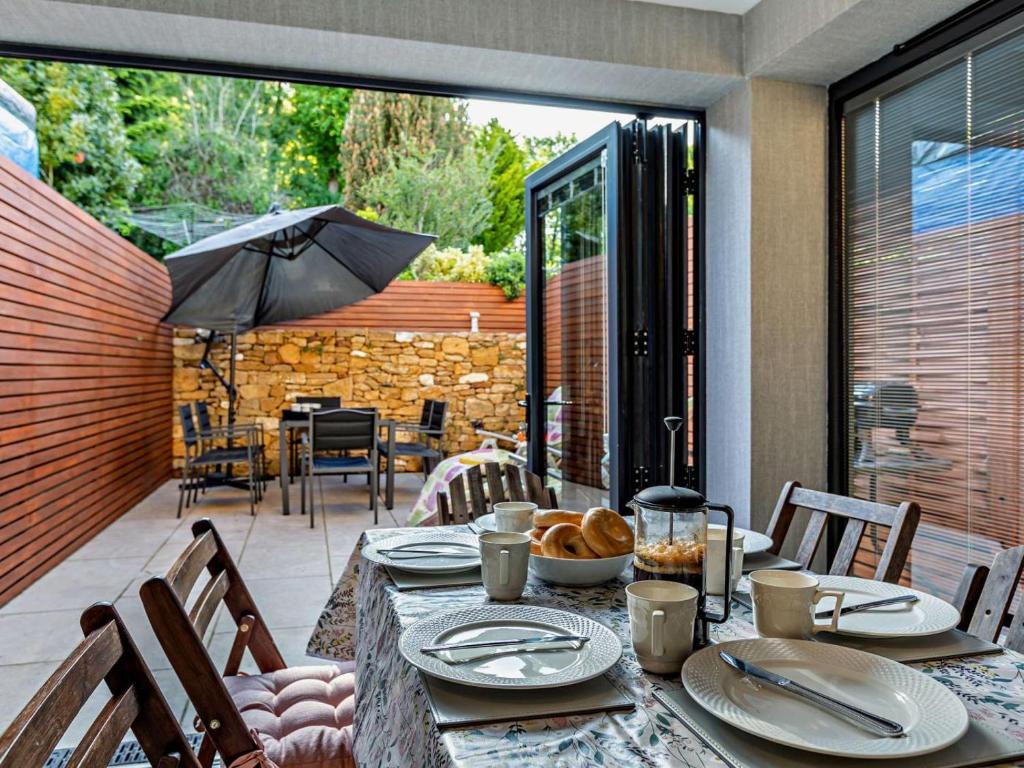 a dining table with an umbrella on a patio at 3 Bed in Montacute oc-92227 in Montacute