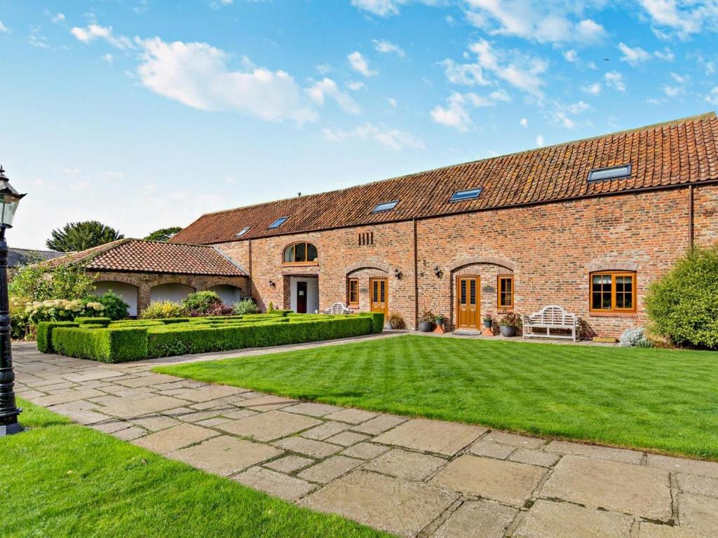 an exterior view of a brick house with a lawn at 2 Bed in Driffield oc-79280 in Wold Newton