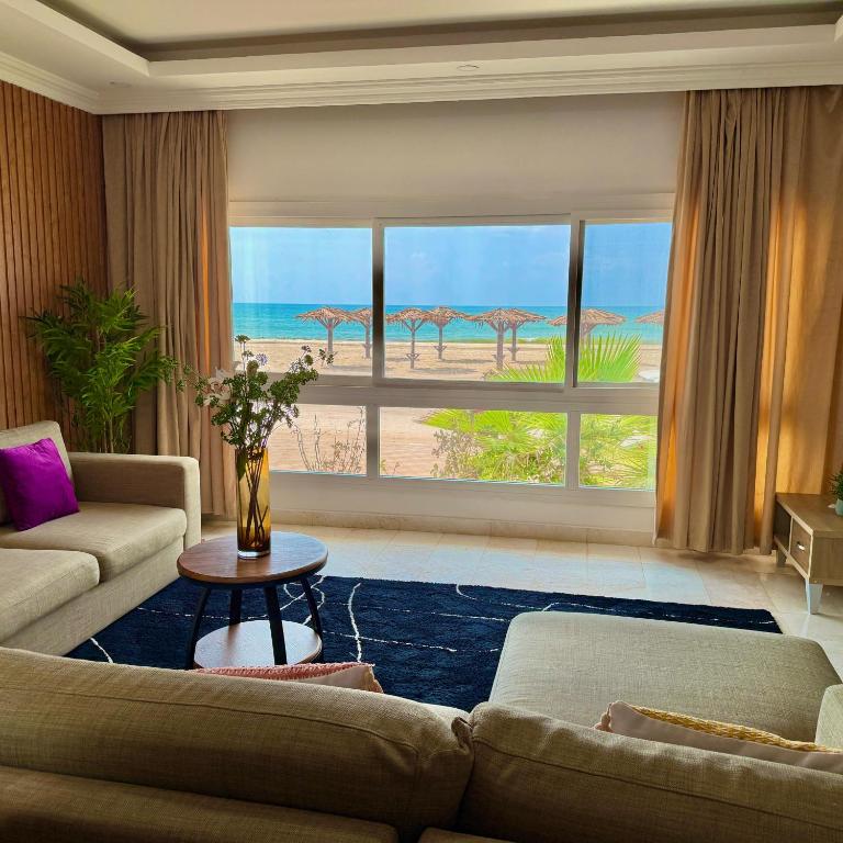 a living room with a view of the beach at Beautiful Salalah Beach Apartments - 1 by Beautiful Salalah Tours in Salalah