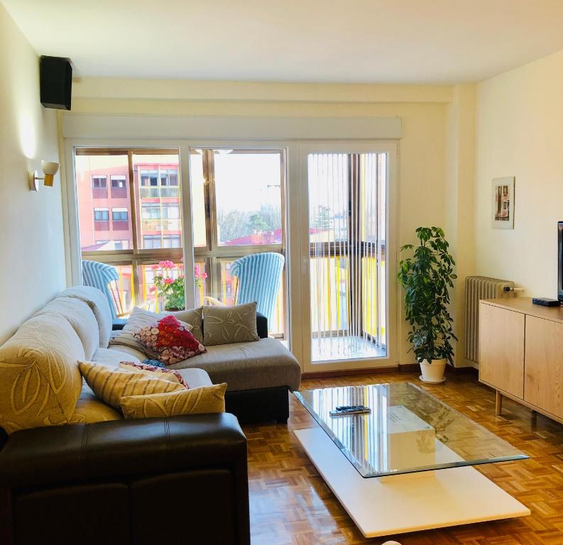 a living room with a couch and a glass table at Piso céntrico y luminoso in León