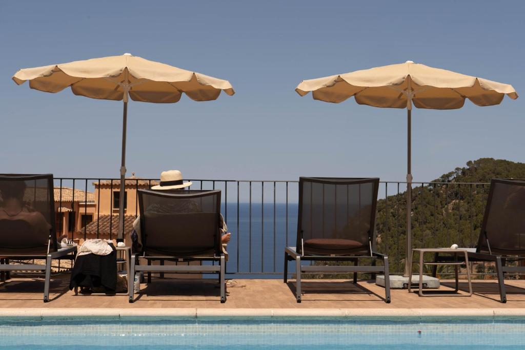 a group of chairs and umbrellas next to a pool at Maristel Hotel & Spa - Adults Only in Estellencs