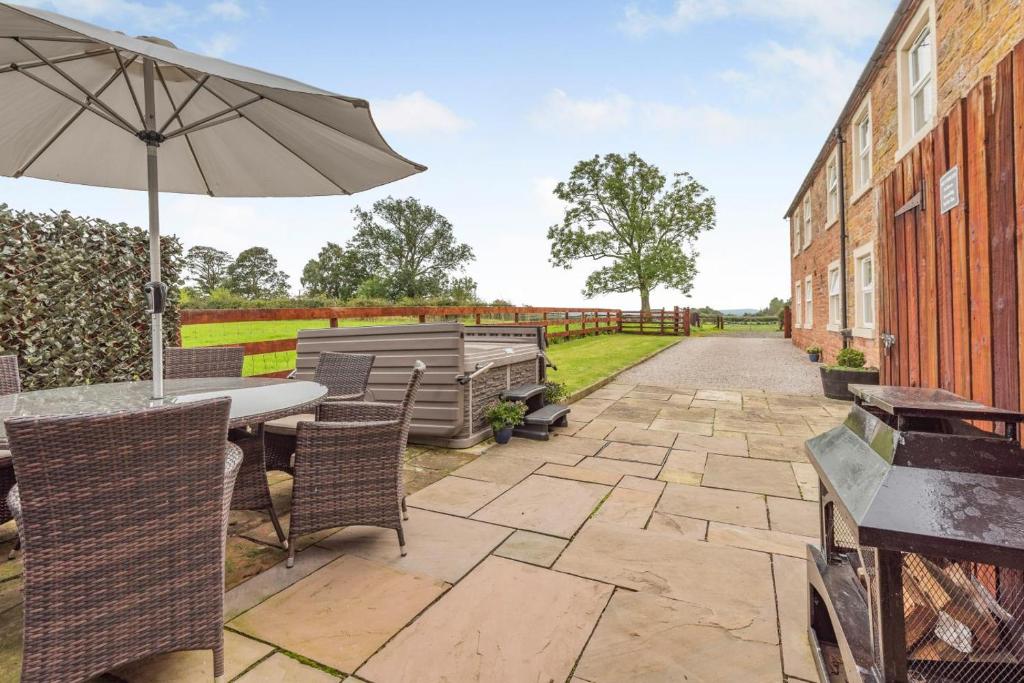 a patio with a table and chairs and an umbrella at 3 Bed in Scaleby oc-b33069 in Scaleby