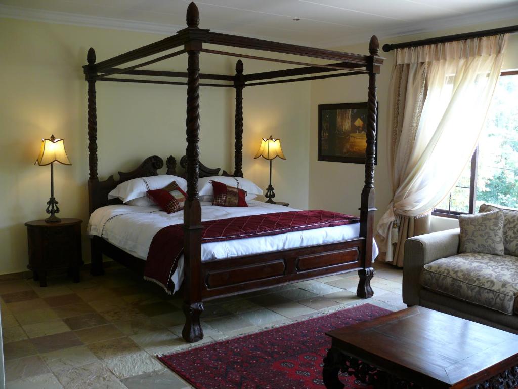 a bedroom with a canopy bed and a couch at 42onKing in Centurion