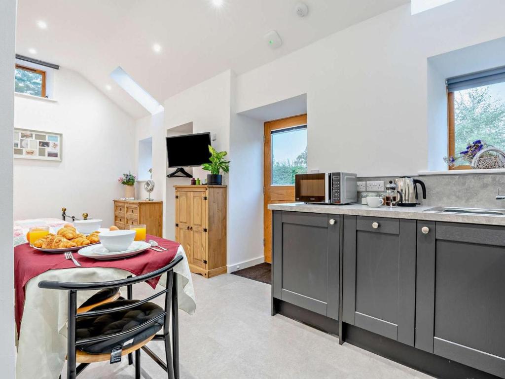 a kitchen with grey cabinets and a table with a red table cloth at 1 Bed in Pickering oc-96309 in Allerston