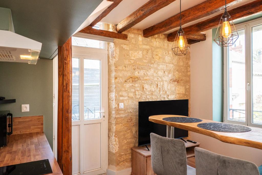 a dining room with a table and a fireplace at Appartements en centre ville à Châteauroux Indre in Châteauroux