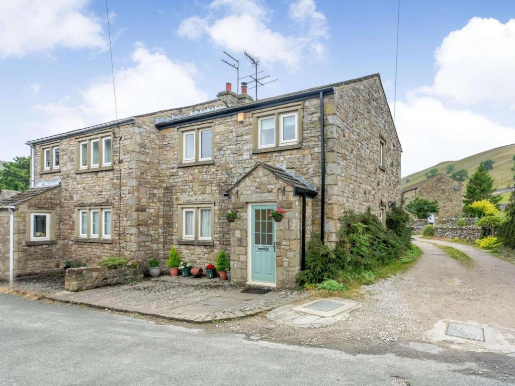 an old stone house with a blue door at 2 Bed in Skipton oc-87598 in Kettlewell