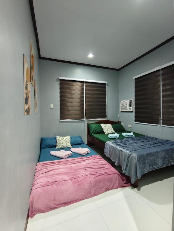 a room with two beds in a room at Aquino Stays in Luna