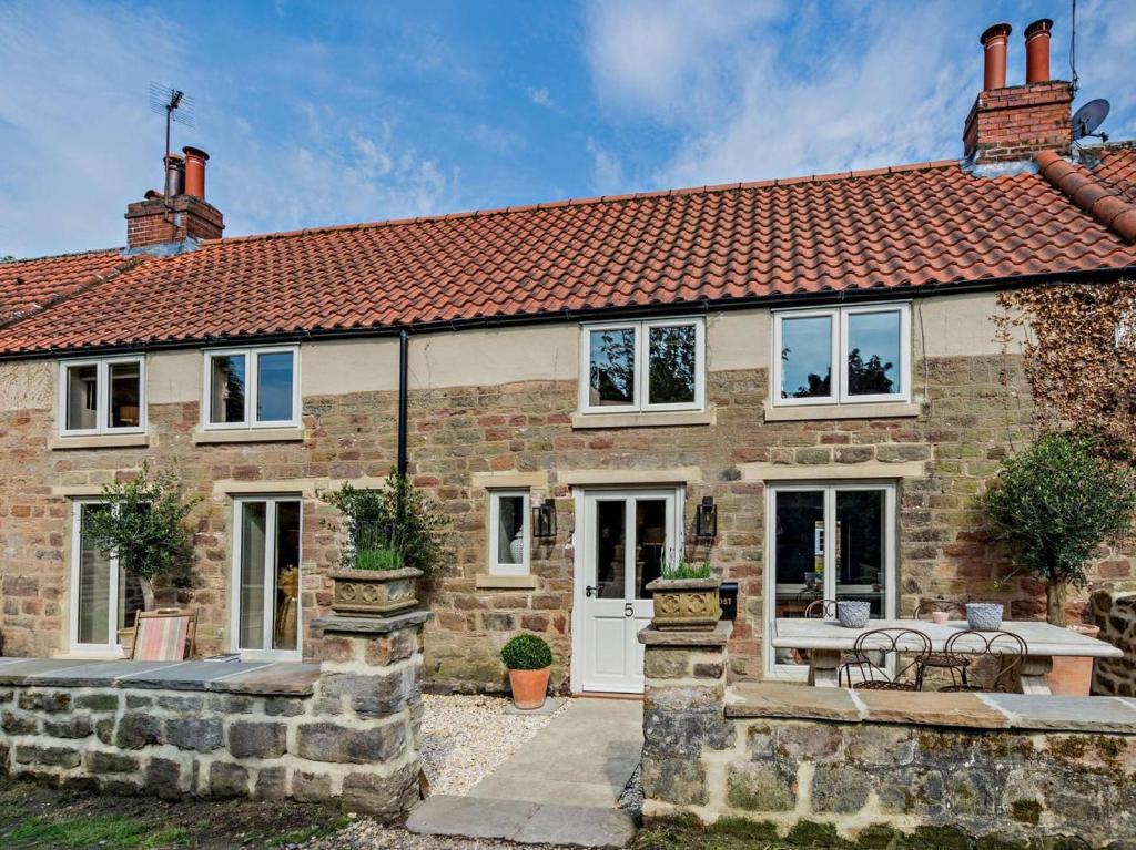 a brick house with a table and chairs in front of it at 2 Bed in Knaresborough oc-95078 in Brompton