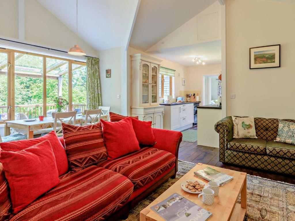 a living room with a red couch and a table at 3 Bed in Watchet oc-95161 in Washford