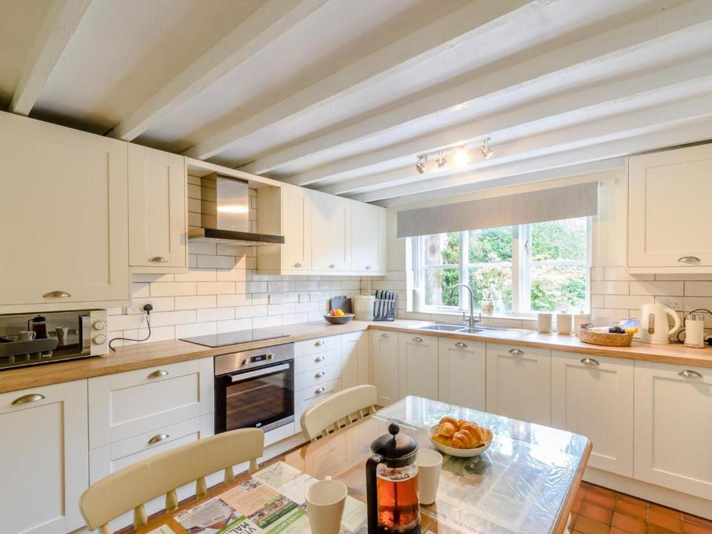 a kitchen with white cabinets and a table at 2 Bed in Malton oc-78794 in Norton
