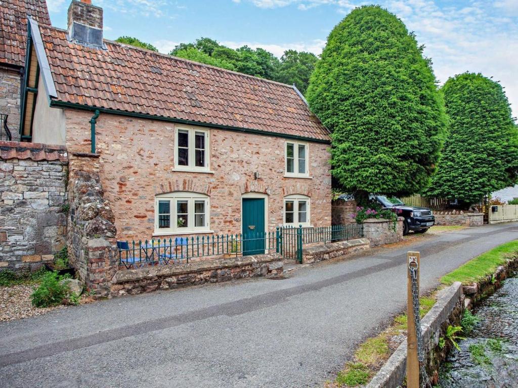 a brick house with a green door on a street at 1 Bed in Bristol oc-95178 in Blagdon
