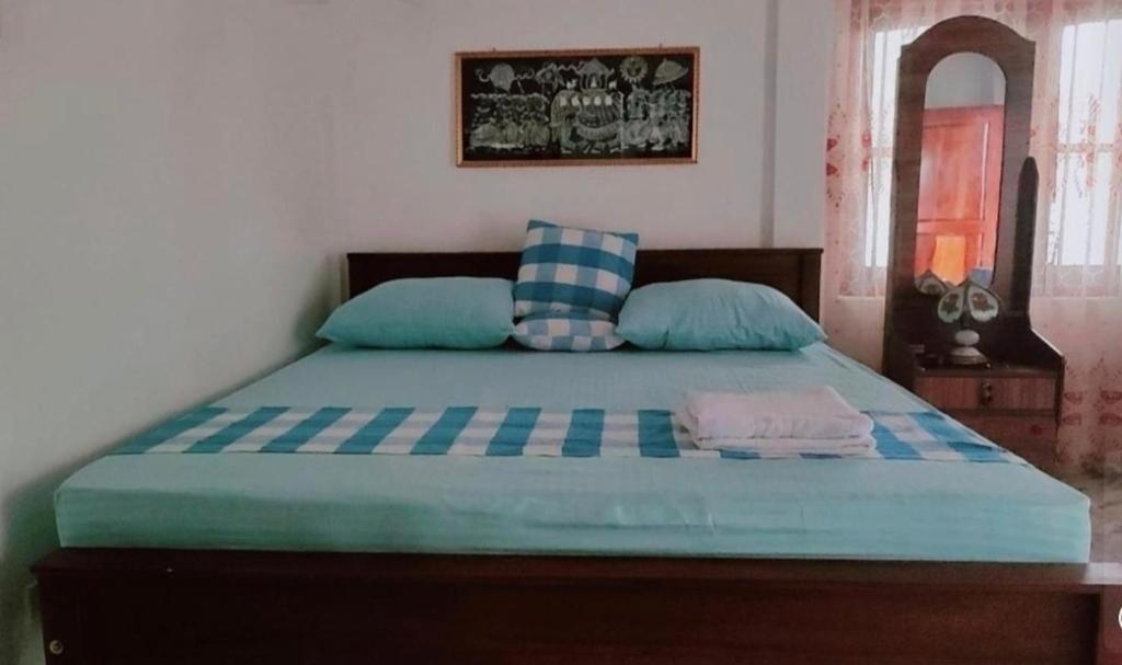 a bedroom with a bed with blue sheets and blue pillows at HindaHaven in Weligama