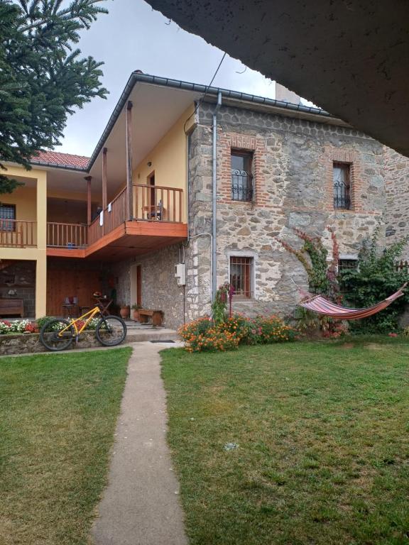 a stone house with a balcony and a yard at Traditional Guesthouse Vrigiis in Agios Germanos