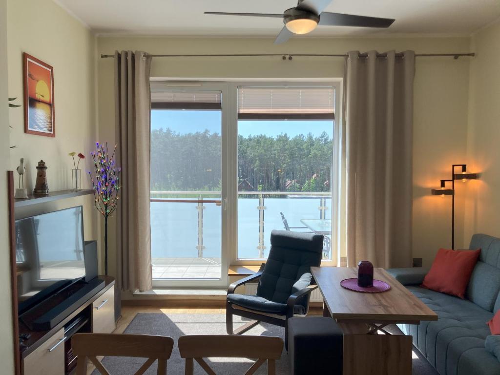a living room with a couch and a table and a tv at Aquamarina Turkus Apartament 253 in Międzyzdroje