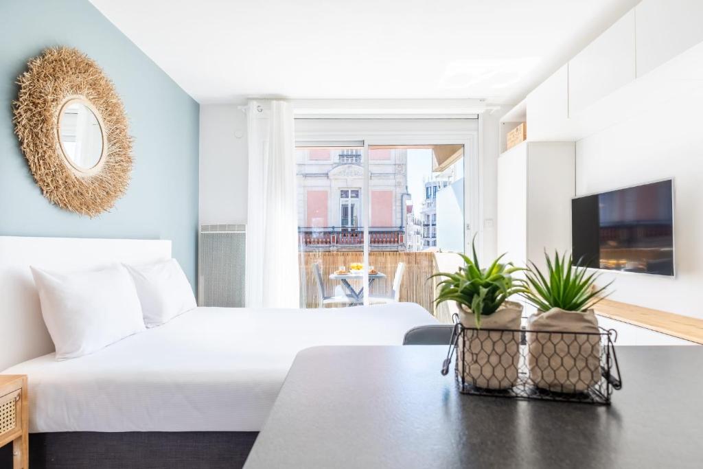 a bedroom with a bed and a table with plants at La Pomponnette du Bassin in Arcachon