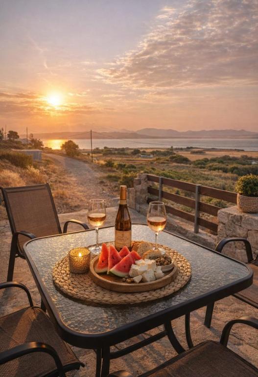 a table with a plate of fruit and wine glasses at Vasileris Home in Moúdhros