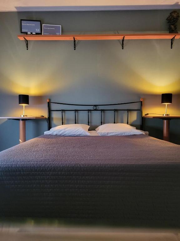 a bedroom with a large bed with two lamps at Narva Apartments in Narva