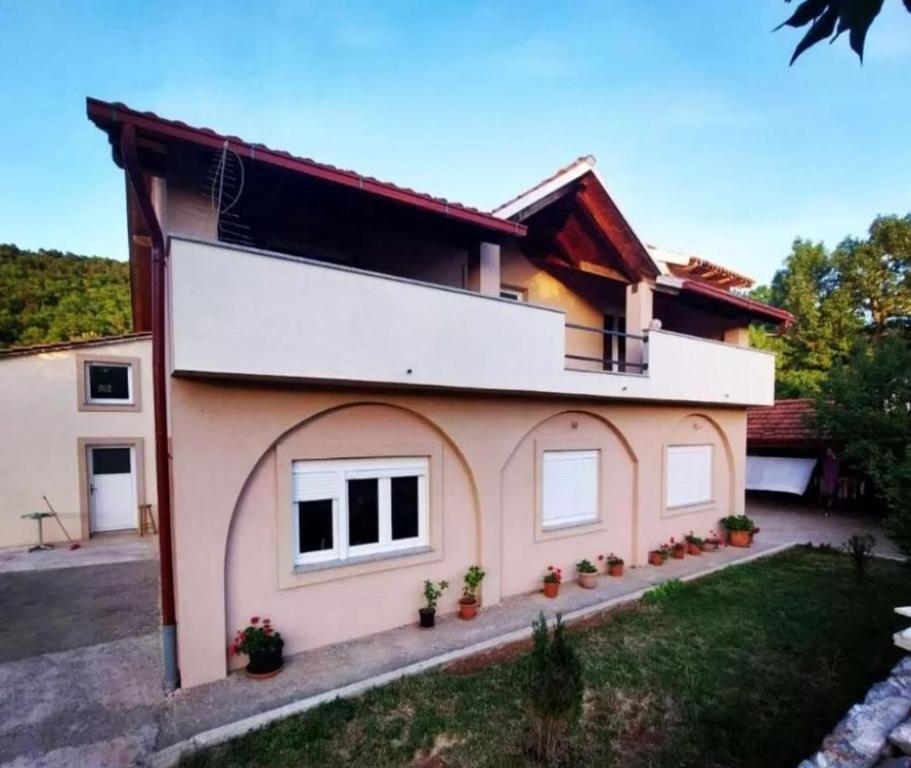a house with a lot of plants in front of it at Apartments Velebit house in Biljevine