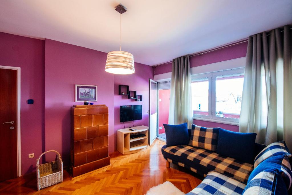 a living room with purple walls and a couch at Marina Bay Apartment in Zadar