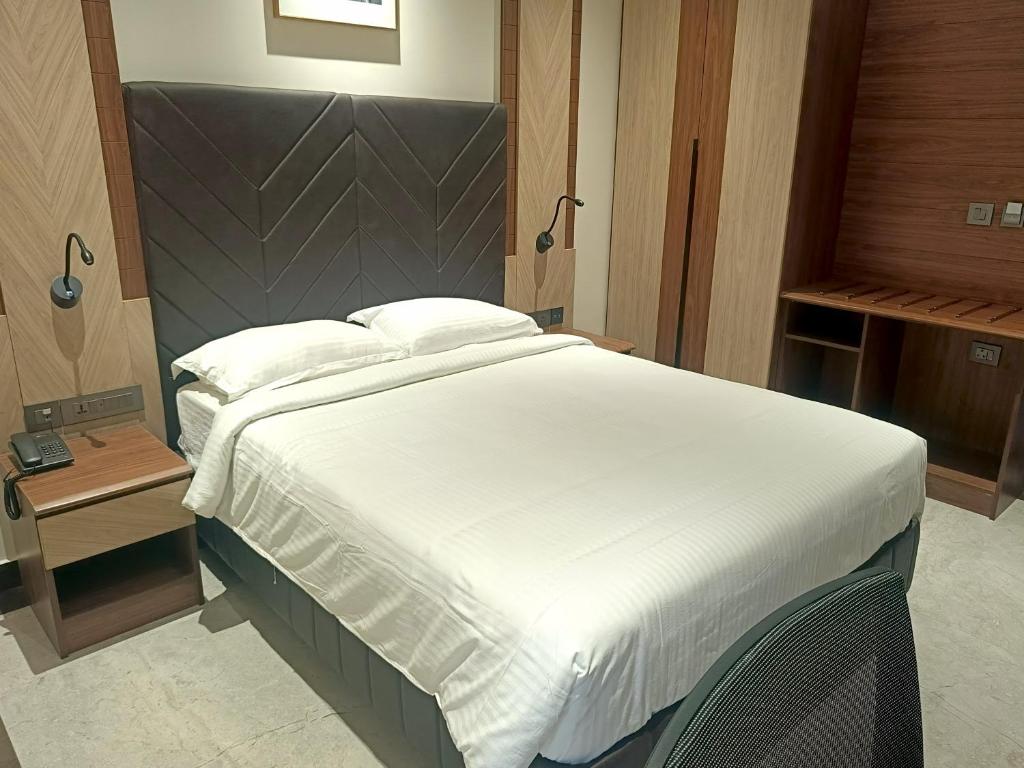 a bedroom with a large bed with a white comforter at Crystal Residency - Panjappur Trichy in Pūngudi