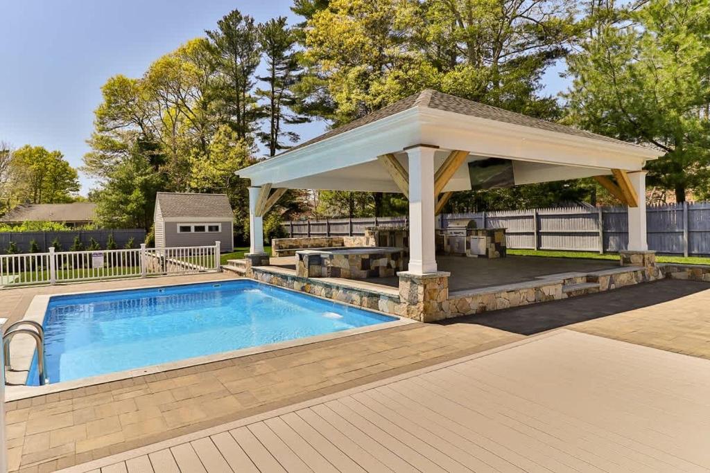 a gazebo with a pool in a yard at Beachside family POOLSPAOPEN20thAPril in Barnstable