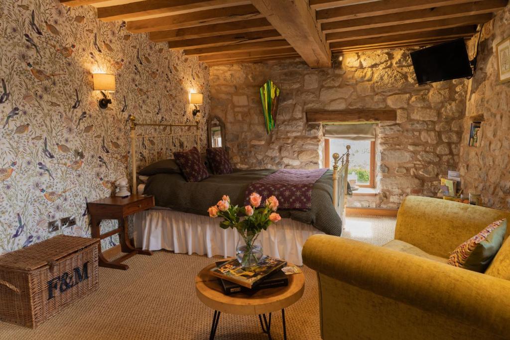 a bedroom with a bed and a couch and a table at The Cowshed in Llangollen