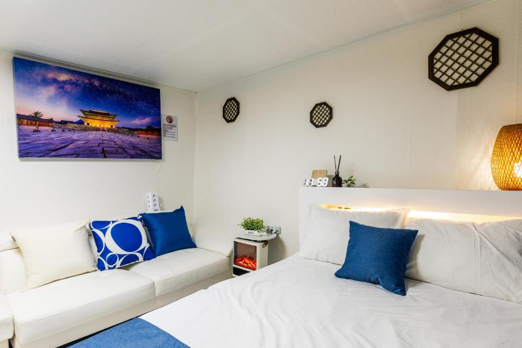 a bedroom with a white bed and a couch at 홍대 stay yoo - Hongdae 3min Station Cozy House in Seoul