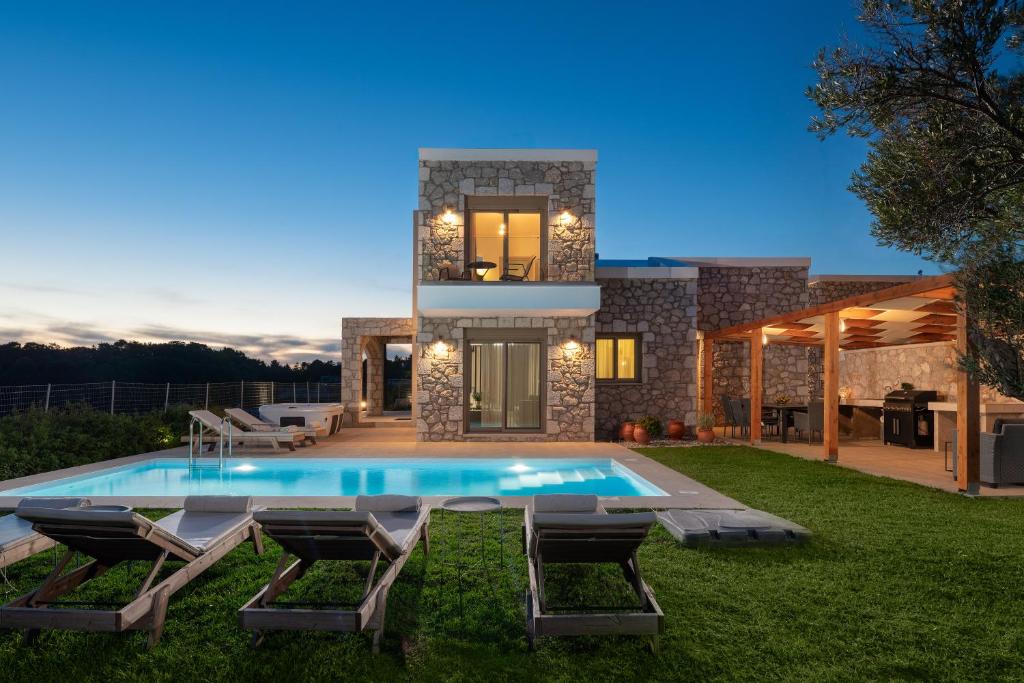 a house with a swimming pool in the yard at Drakos Estate - Luxury Pool Villas in Asgourou