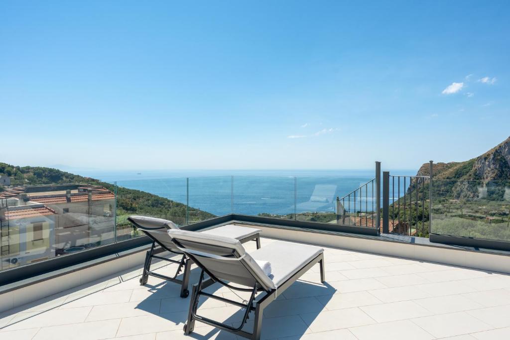 a patio with two chairs and a table on a balcony at Torre Saracena Massa Lubrense in Massa Lubrense