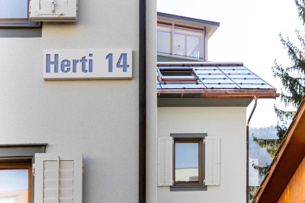 a white building with a sign that reads hert at Herti14 Serviced Apartments in Ennetbaden