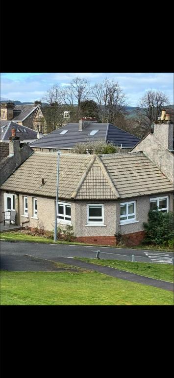 a brick house with a roof on a street at Dove Cottage in Greenock