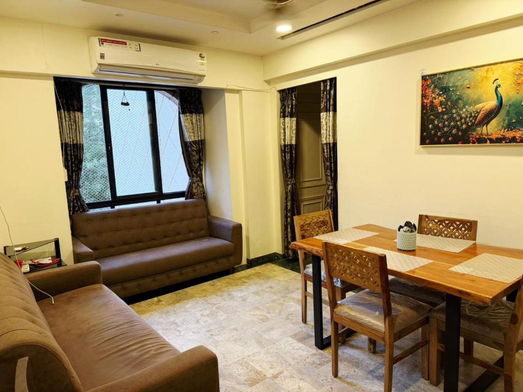 a living room with a table and a couch at Divine Abode in Thane