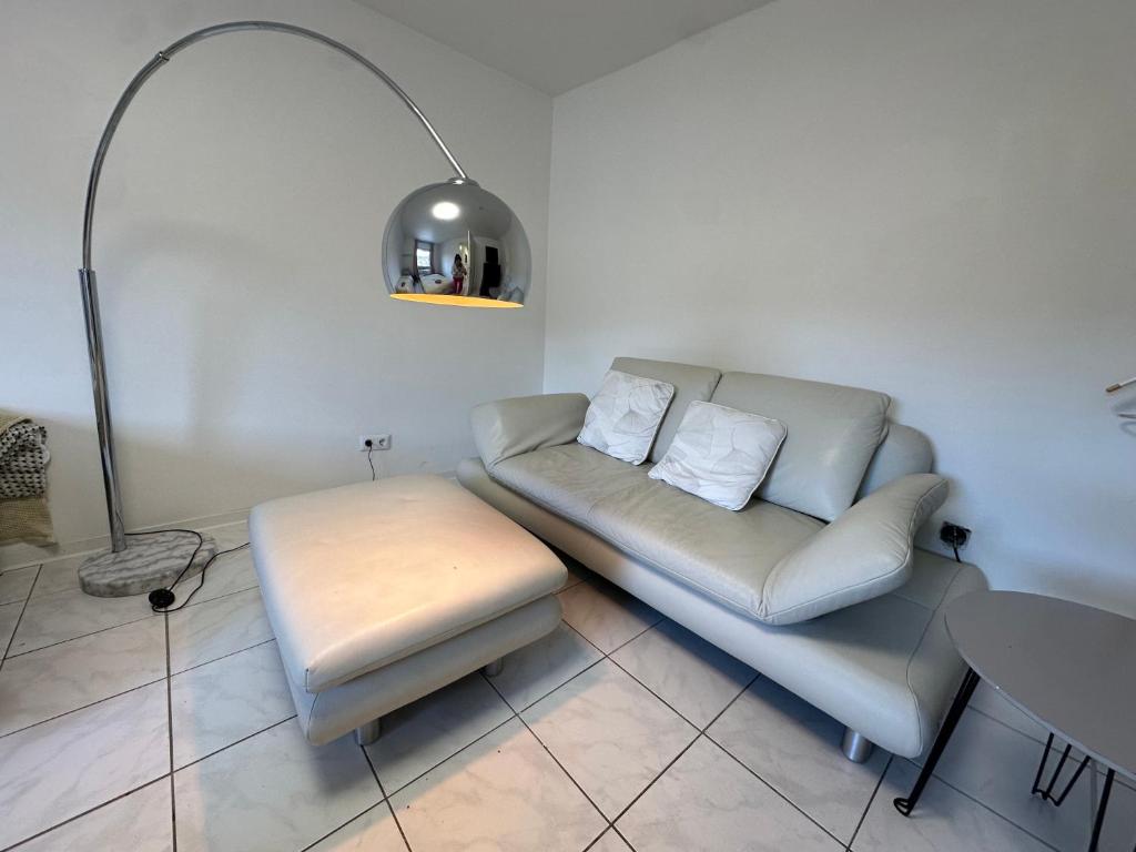 a living room with a couch and a stool at Zimmer für 2 Monteure in Heppenheim Kirschhausen in Kirschhausen