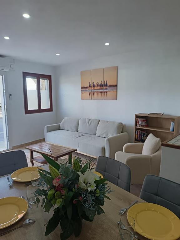 a living room with a table and a couch at Maison le Flamant in Port-Saint-Louis-du-Rhône